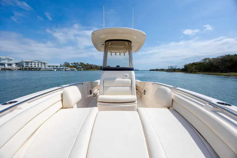 Slide: The Image of 2024 Grady-White Fisherman 236 boat on serene water, showcasing spacious seating and sleek design. - 24