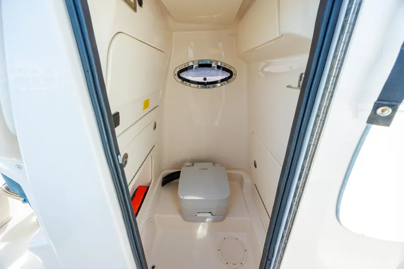 Slide: The Image of 2024 Grady-White Fisherman 236 boat interior with compact marine toilet. - 27
