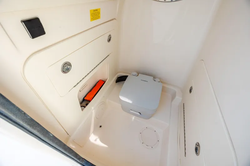 Slide: The Image of 2024 Grady-White Fisherman 236 boat interior storage compartment with portable toilet. - 28