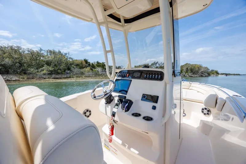 Slide: The Image of 2024 Grady-White Fisherman 236 boat interior with steering console, on a serene waterway. - 30
