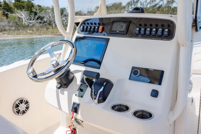 Slide: The Image of 2024 Grady-White Fisherman 236 helm with steering wheel, controls, and navigation display. - 31