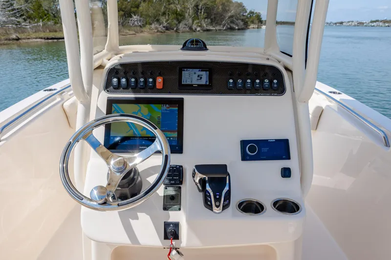 Slide: The Image of 2024 Grady-White Fisherman 236 boat dashboard with steering wheel and navigation controls. - 33