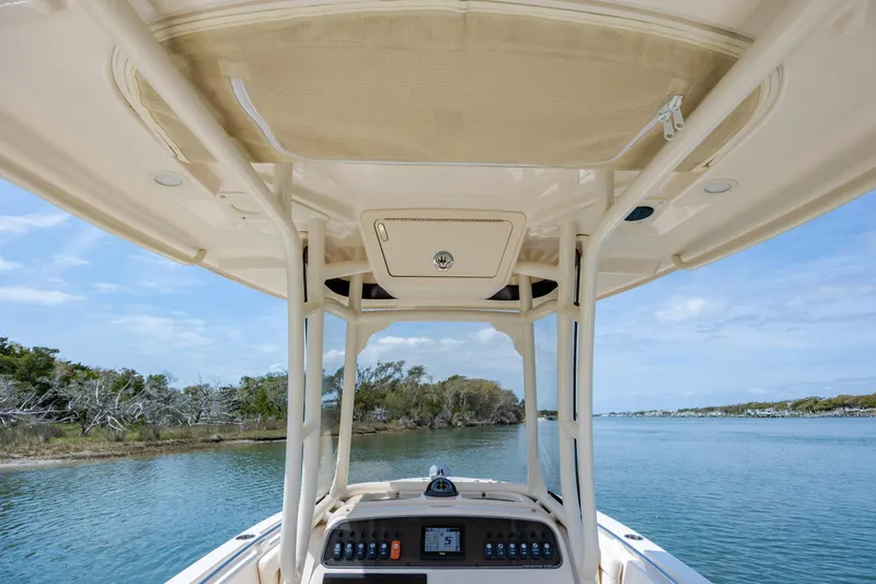 Slide: The Image of 2024 Grady-White Fisherman 236 boat console with canopy, navigating serene waters. - 34