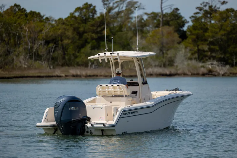 Slide: The Image of 2024 Grady-White Fisherman 236 boat cruising on a serene lake with lush greenery. - 4