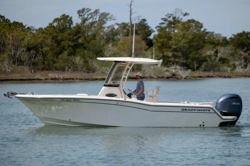 Slide: The Image of 2024 Grady-White Fisherman 236 boat cruising on a calm lake with lush greenery. - 7