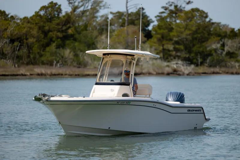 Slide: The Image of 2024 Grady-White Fisherman 236 boat cruising on a serene lake with lush greenery. - 9