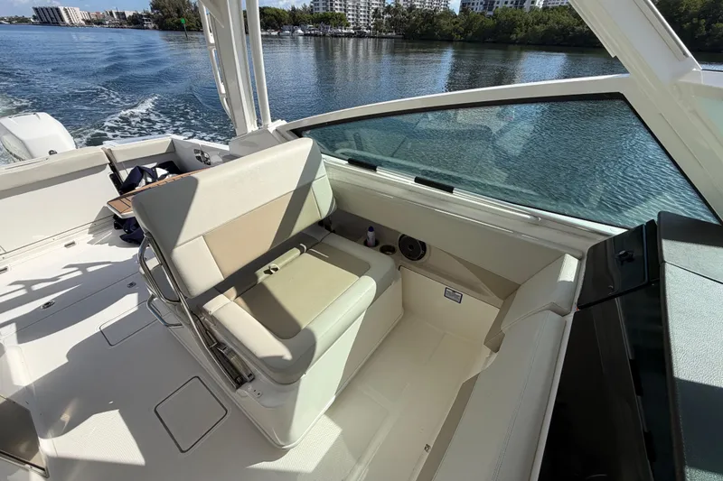 Slide: The Image of 2021 Boston Whaler 280 Vantage interior with seating, on a calm waterway. - 11