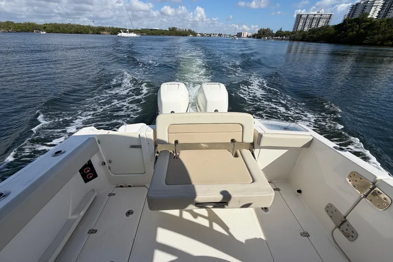 Slide: The Image of 2021 Boston Whaler 280 Vantage cruising on a sunny day, showcasing rear seating and twin engines. - 17