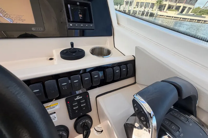 Slide: The Image of 2021 Boston Whaler 280 Vantage helm with controls, switches, and navigation display. - 23