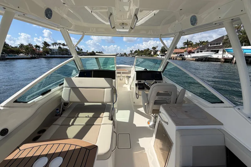 Slide: The Image of 2021 Boston Whaler 280 Vantage boat interior with seating and helm, docked by waterfront homes. - 24