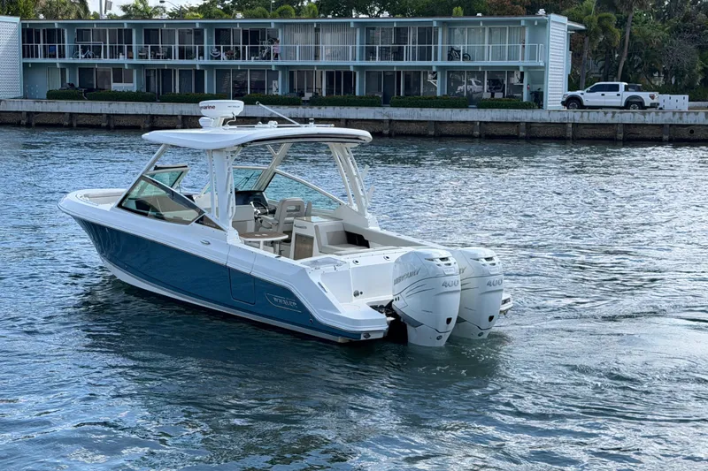 Slide: The Image of 2021 Boston Whaler 280 Vantage boat cruising on water near waterfront buildings. - 30