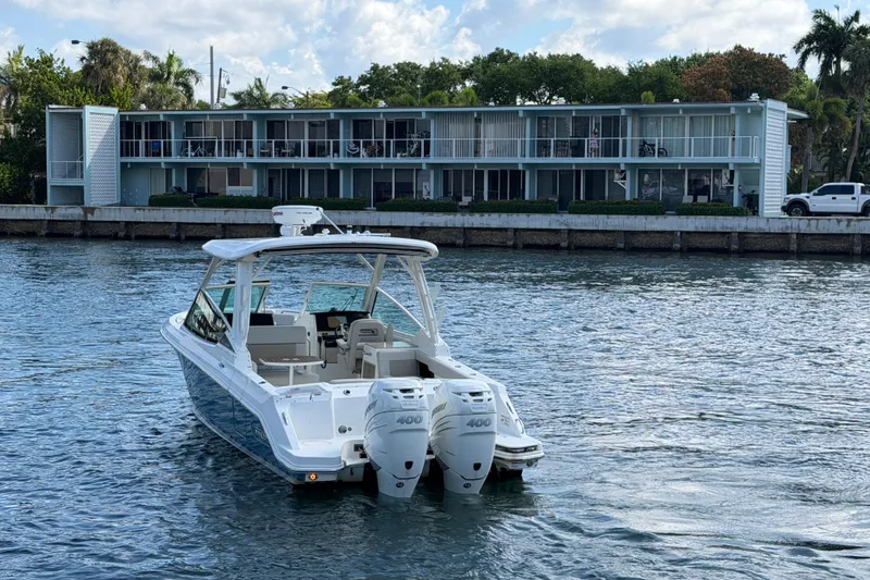 Slide: The Image of 2021 Boston Whaler 280 Vantage boat on water near modern waterfront building. - 34