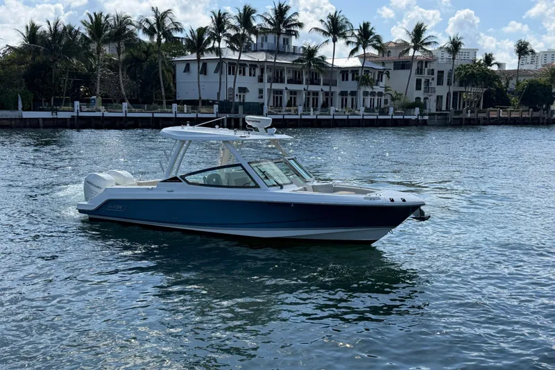 Slide: The Image of 2021 Boston Whaler 280 Vantage boat cruising on a sunny waterfront with palm trees. - 39