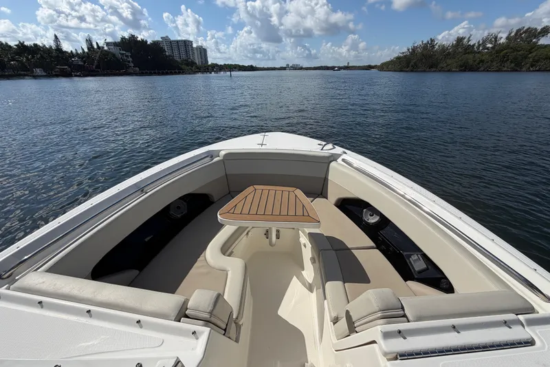 Slide: The Image of 2021 Boston Whaler 280 Vantage boat interior with seating and table on calm water. - 4