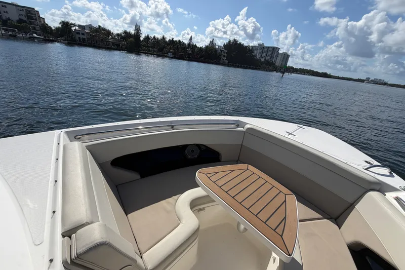 Slide: The Image of 2021 Boston Whaler 280 Vantage boat interior with seating and table on calm water. - 6