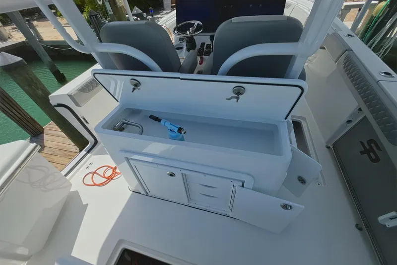 Slide: The Image of 2024 Sea Pro 322 Offshore boat interior with open storage compartment and seating. - 10