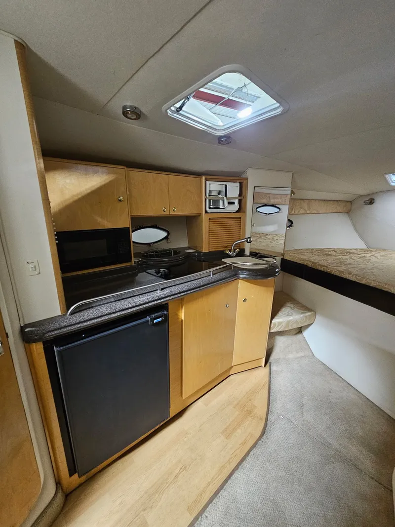 Slide: The Image of Interior of 2001 Larson Cabrio 330 yacht featuring kitchen and sleeping area. - 16