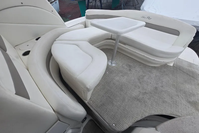Slide: The Image of 2003 Sea Ray Sundancer 320 interior with white seating and table on carpeted deck. - 10