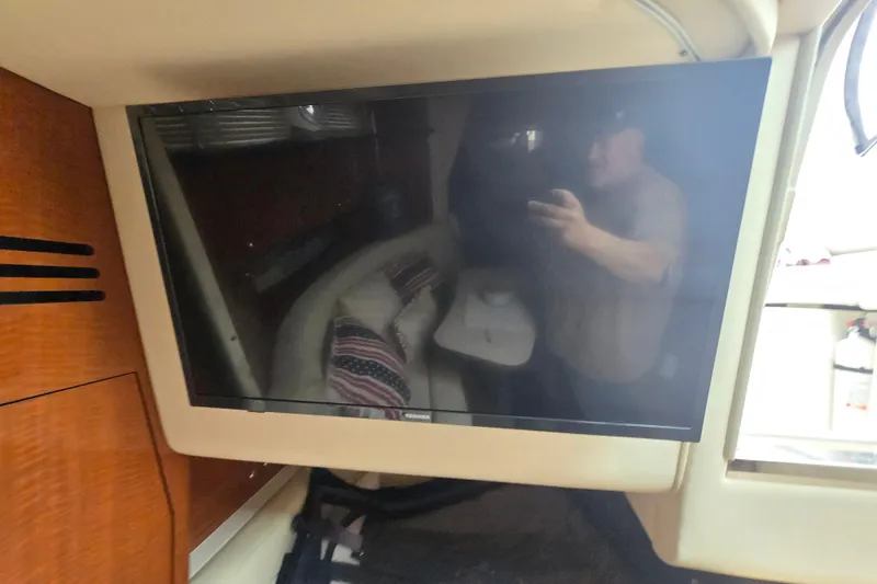 Slide: The Image of Flat-screen TV inside 2003 Sea Ray Sundancer 320 yacht cabin, reflecting interior seating area. - 23