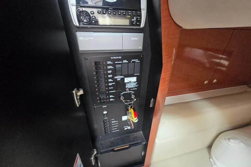 Slide: The Image of Control panel inside a 2003 Sea Ray Sundancer 320 boat, featuring audio system and switches. - 28