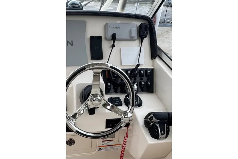 Slide: The Image of 2023 Grady-White Freedom 285 boat dashboard with steering wheel and Garmin electronics. - 6