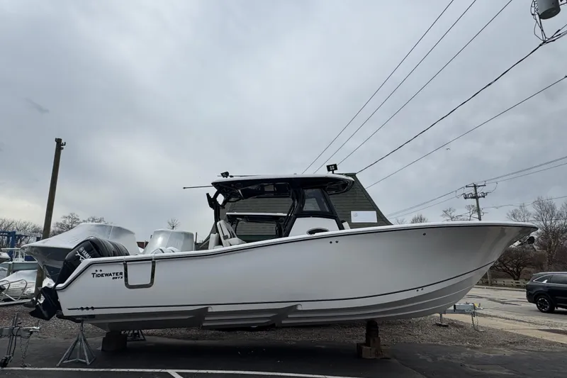 The Image of 2026 Tidewater 302 CC Adventure boat displayed outdoors on a cloudy day. - 1