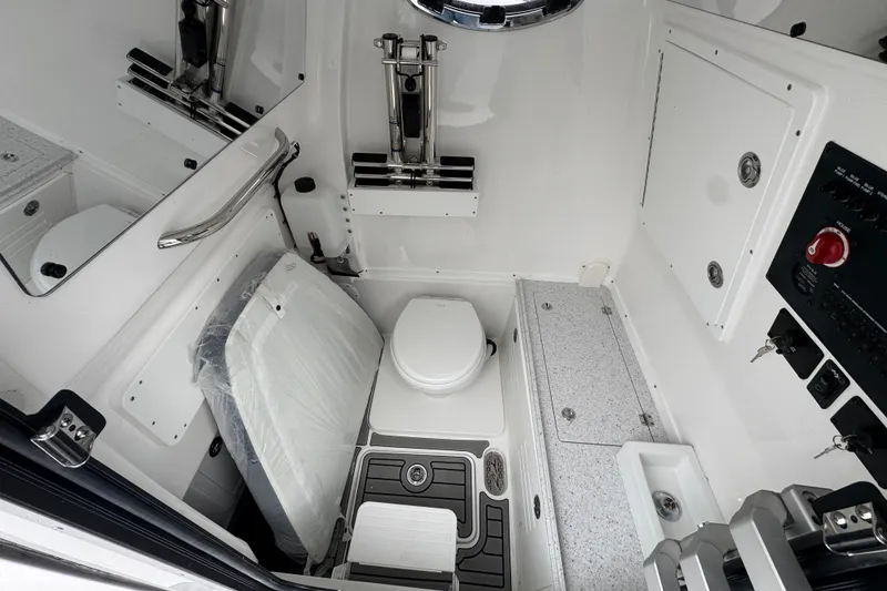 Slide: The Image of Interior of 2026 Tidewater 302 CC Adventure boat, featuring a compact marine toilet. - 19