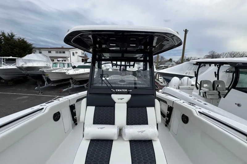 Slide: The Image of 2026 Tidewater 302 CC Adventure boat, sleek design, docked among other vessels. - 22