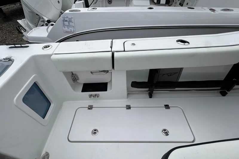 Slide: The Image of 2026 Tidewater 302 CC Adventure boat interior, featuring sleek white seating and storage compartments. - 8