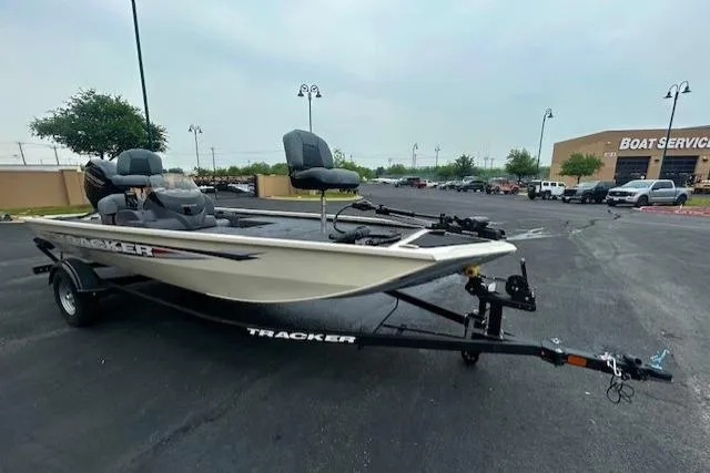 Slide: The Image of 2026 Tracker Pro 170 boat on trailer in parking lot near boat service center. - 2