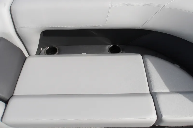 Slide: The Image of 2026 Sun Tracker Party Barge 18 DLX seating area with cup holders, featuring sleek gray upholstery. - 17
