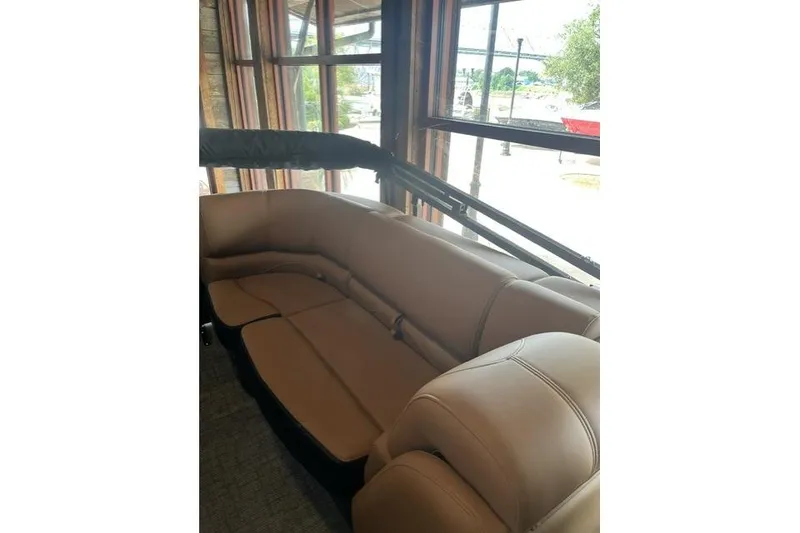 Slide: The Image of Luxurious interior seating of 2026 Regency 230 DL boat, featuring plush tan upholstery. - 11