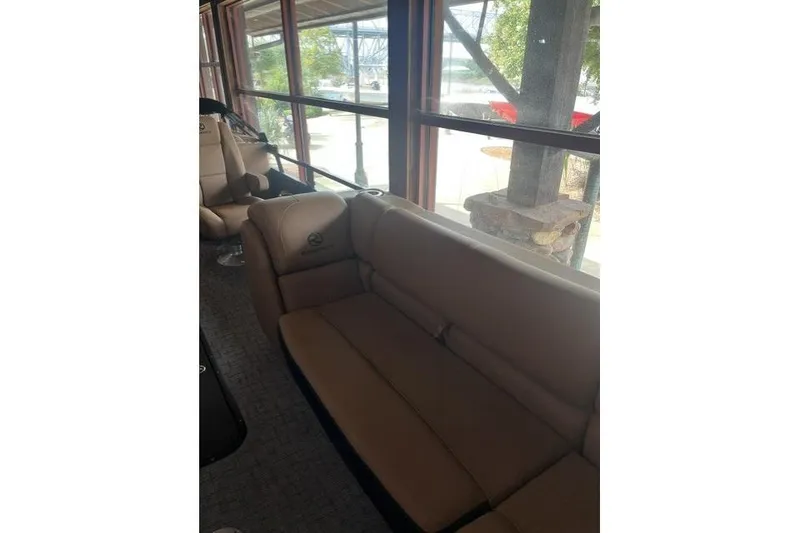 Slide: The Image of Interior of 2026 Regency 230 DL boat with beige seating and large windows. - 8