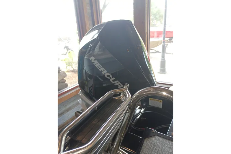 Slide: The Image of 2026 Regency 230 DL boat with Mercury outboard motor in showroom. - 9