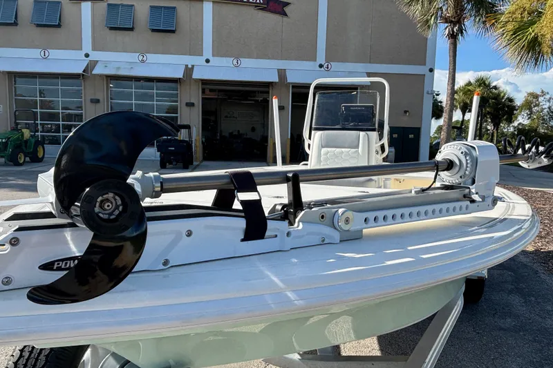 Slide: The Image of 2026 Mako 18 Pro Skiff with trolling motor, parked outside a building. - 5