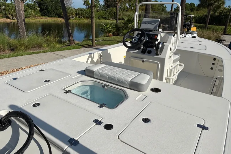 Slide: The Image of 2026 Mako 18 Pro Skiff boat interior with console and seating, near a scenic waterway. - 6