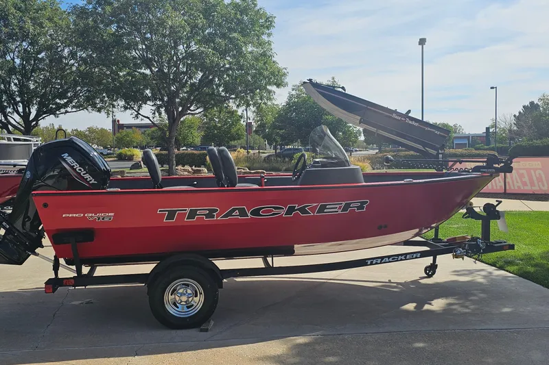 The Image of 2026 Tracker Pro Guide V-16 SC boat on trailer, parked outdoors. - 0