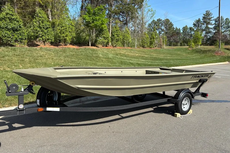 Slide: The Image of 2026 Tracker Grizzly 1754 Utility boat on trailer, parked outdoors. - 2