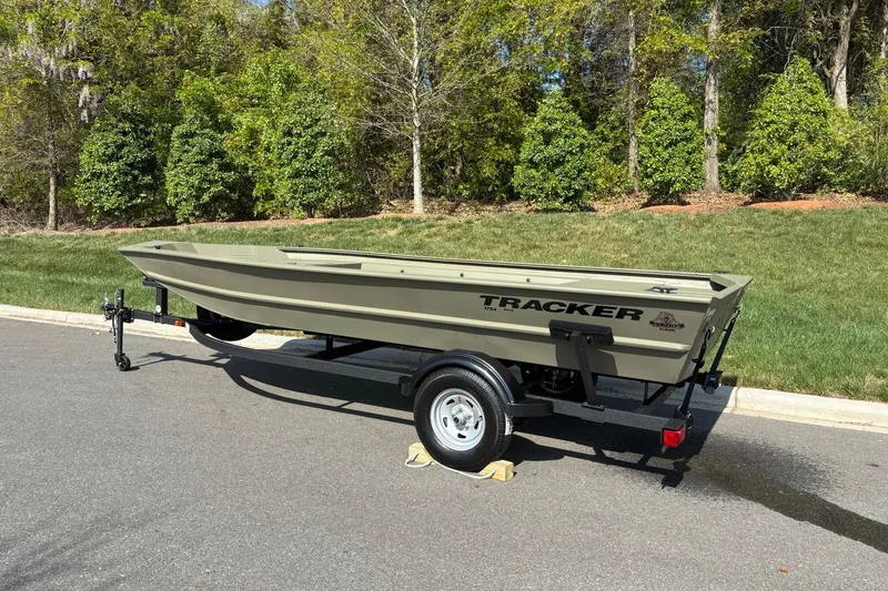 Slide: The Image of 2026 Tracker Grizzly 1754 Utility boat on trailer, parked on a sunny road. - 3