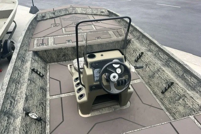The Image of 2026 Tracker Grizzly 2072 CC boat interior with steering console and camouflage design. - 0
