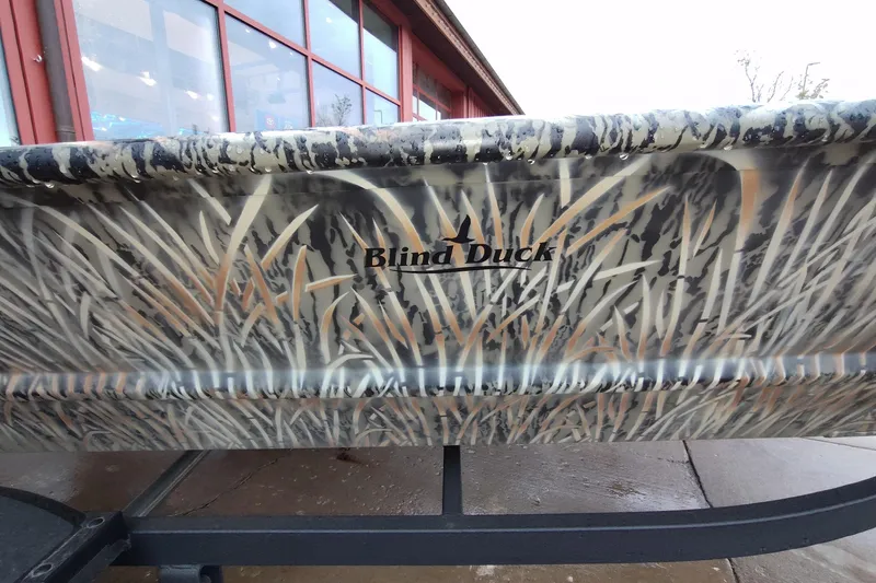 Slide: The Image of 2026 Tracker Grizzly 1648 Utility boat with camo design and "Blind Duck" branding. - 2