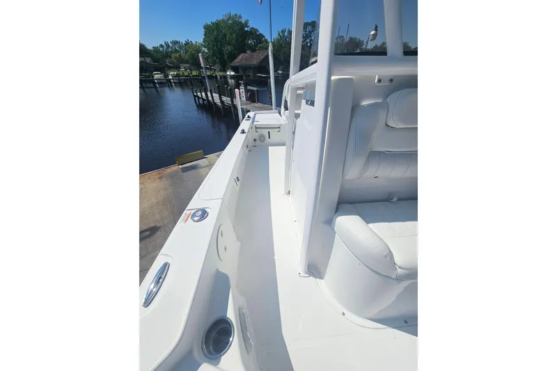 Slide: The Image of 2017 Sea Hunt BX 22 BR boat interior with white seating, docked by a serene waterfront. - 22