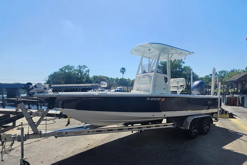 Slide: The Image of 2017 Sea Hunt BX 22 BR boat on trailer, parked near waterfront under clear blue sky. - 6