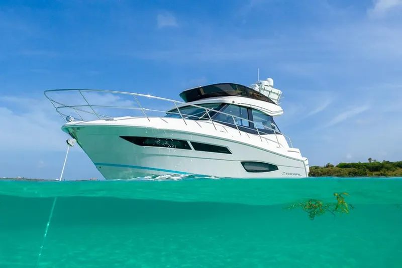 Slide: The Image of Manufacturer Provided Image: 2026 Regal 38 FXO yacht cruising in clear turquoise waters under a bright blue sky. - 2