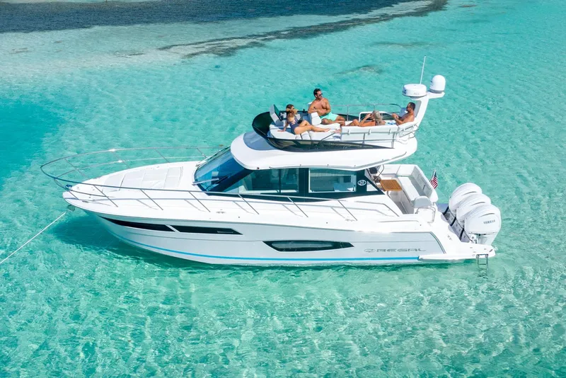 Slide: The Image of Manufacturer Provided Image: 2026 Regal 38 FXO yacht cruising in clear turquoise waters with passengers relaxing on deck. - 5