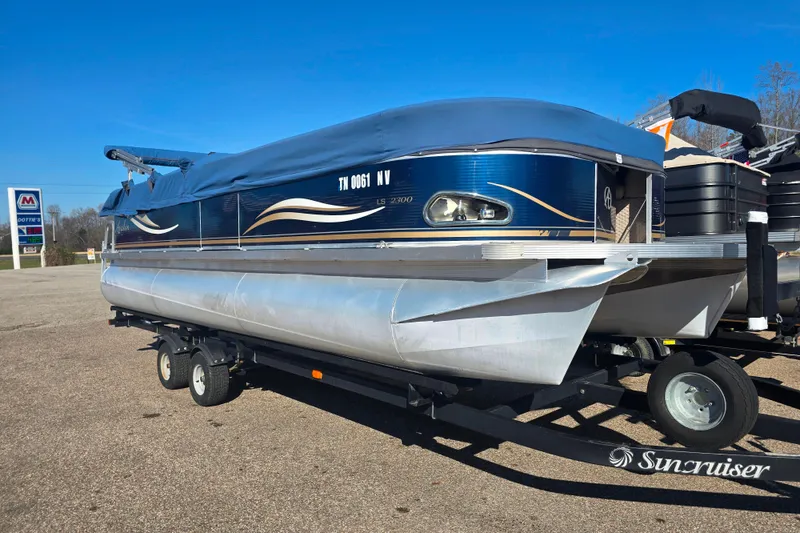 The Image of Pontoon boat Avalon L32300, 2012 model, on trailer in parking lot. - 1