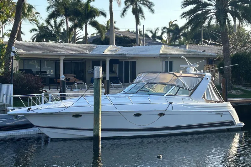 The Image of 2001 Formula 41 Performance Cruiser docked by a waterfront home with palm trees. - 0