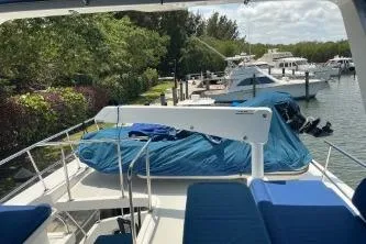 Slide: The Image of 2010 DeFever 48 Trawler docked, surrounded by lush greenery and other boats. - 47