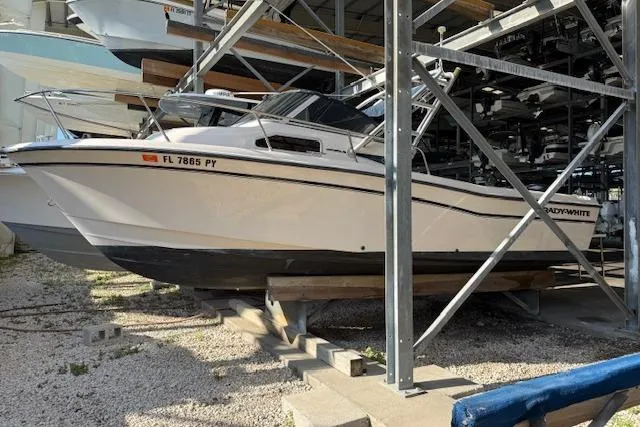 Slide: The Image of 2000 Grady-White Seafarer 22 boat docked, featuring spacious seating and Yamaha outboard motor. - 2