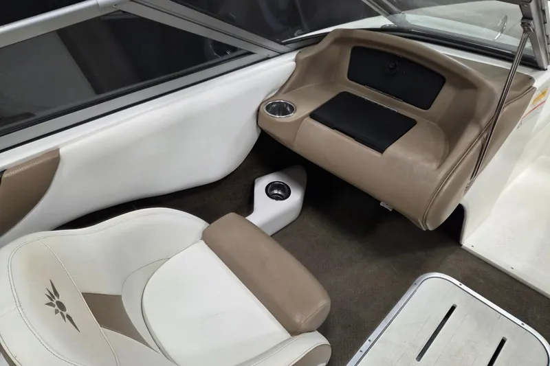 Slide: The Image of Interior of a 2007 Mariah SX19 boat, featuring beige and white seating. - 9